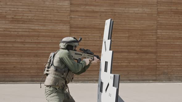 Slow motion of soldier shooting automatic rifle in a range