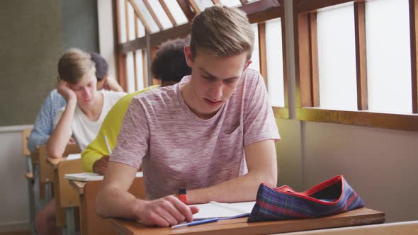 Caucasian boy reading in class