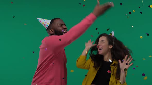 African American Man and White Woman Couple Dancing with Confetti Rain Isolated on Green Screen