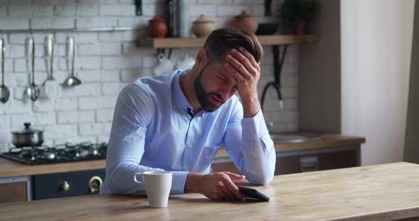 Frustration of Sad Man Looking Smartphone