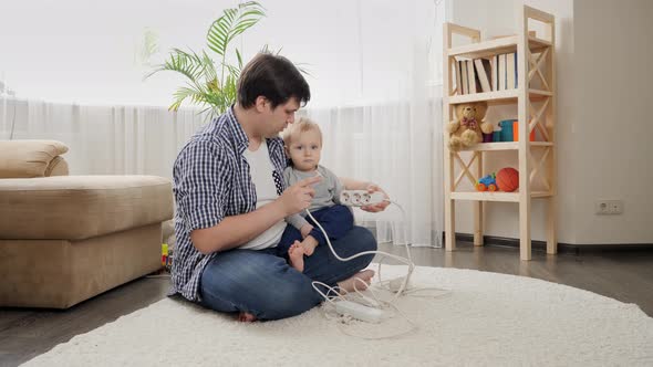 Father teaching his baby son not to touch electric plugs