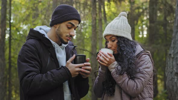 Young Happy Couple Standing in Autumn Forest Relaxing Drinking Hot Tea in Nature Couple in Love