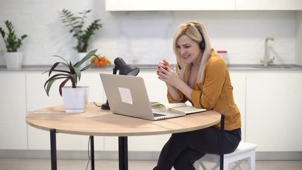 Woman Working with Laptop in Bright Kitchen