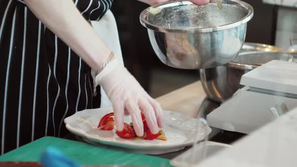 Chefs in Protective Masks and Gloves Prepare Food in the Kitchen of a Restaurant or Hotel High