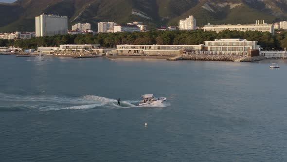 Aerial View Extreme Sport Woman Wakesurfing From Yacht Boat Amazing Sunset Touristic City Seascape