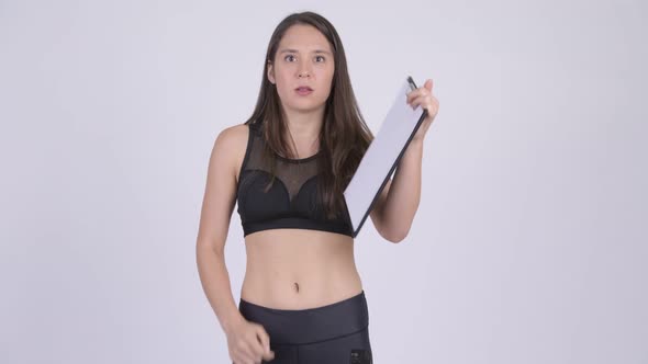 Young Upset Woman Showing Clipboard and Giving Thumbs Down Ready for Gym
