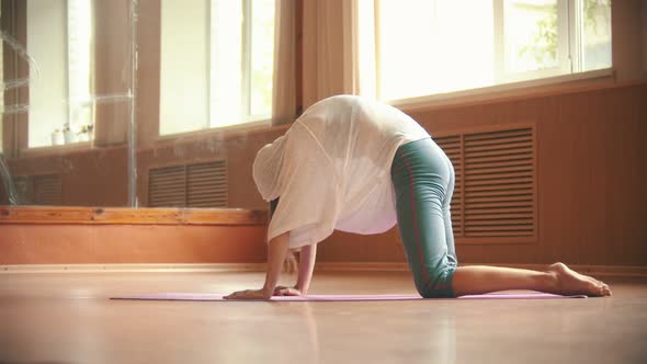 Young Pretty Woman Exercising on the Yoga Mat - Flexing Her Loin