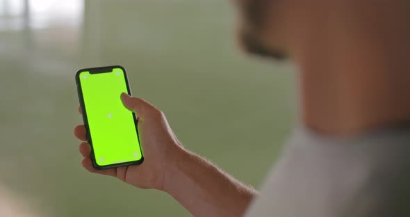 Young Adult Man Using Smartphone with Green Screen During Fitness Sport Workout