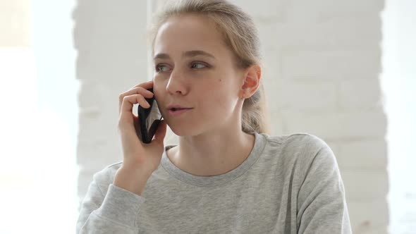 Young Woman Talking on Phone in Loft Workplace