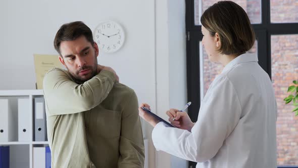 Man Patient with Sore Neck and Doctor at Hospital