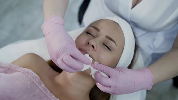 Young Woman Having Cleansing the Skin with Cotton Swabs During Beauty Procedure