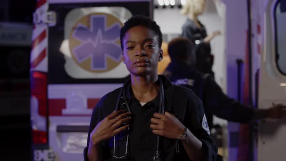 African American Paramedic Standing Outdoors Near Ambulance