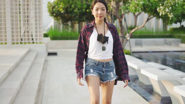 Attractive Asian woman smiling  play skateboard outdoor garden.