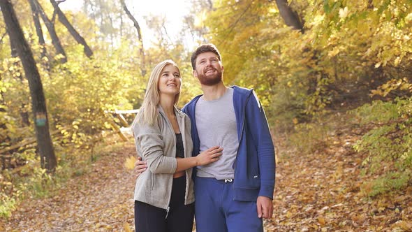 Happy Young Couple Enjoying a Walk in the Autumn Forest Talking After a Run Contemplating the