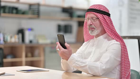 Senior Old Arab Businessman Having Success on Smartphone