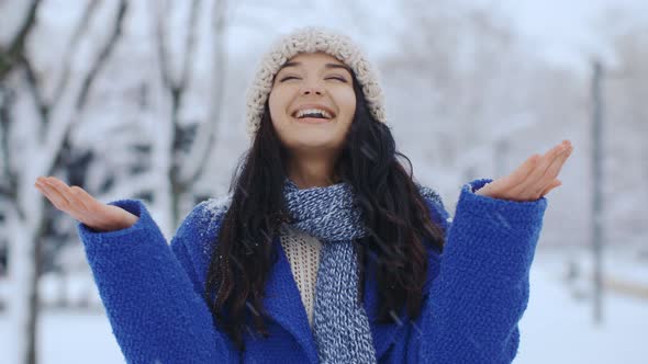 Happy Smiling Woman Having Fun in Winter. Falling Snow. Winter Holidays Concept