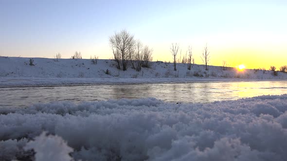 Steam Comes Out of Water and Stream Flowing Under Frozen Ice Sheets in Sunset Morning Time