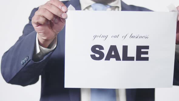 Business Man Posts Sign On Glass Window Going Out Of Business