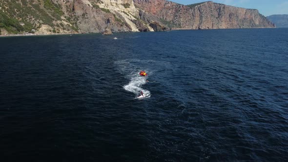 Happy People Swim on Air Mattress Behind a High Speed Water Bike