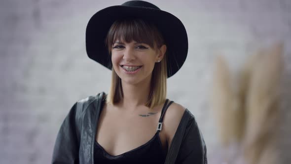 Slim Charming Brunette Woman with Teeth Braces Looking at Camera Smiling Posing Indoors