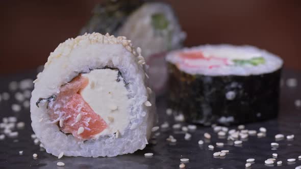 Fresh Sushi Roll with Sesame is Taken with Special Japanese Chopsticks