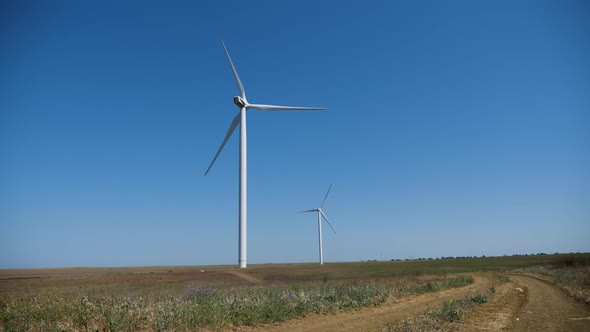 Working Twisting Windmills Stand in a Field in Summer