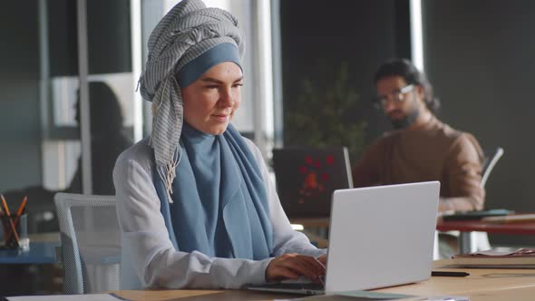 Cheerful Businesswoman in Hijab Posing for Camera in Office