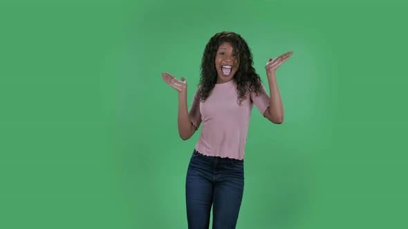 Portrait of Beautiful African American Young Woman Looking at Camera and Performs a Dance of Joy and