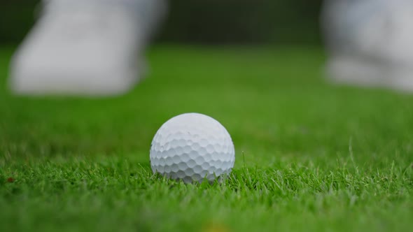 Golf club kicking the ball on green grass close up