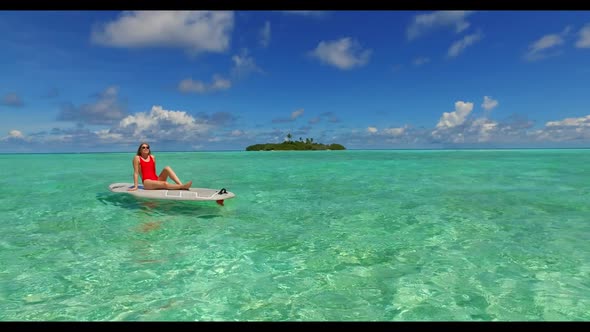 Man and lady tanning on tranquil island beach voyage by blue sea and white sandy background of the M