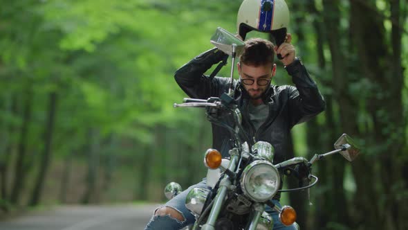 Young man gets on motorcycle and rides away