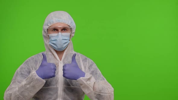 Medical Doctor in Protective PPE Suit Pointing at Right on Blank Space on Chroma Key Background