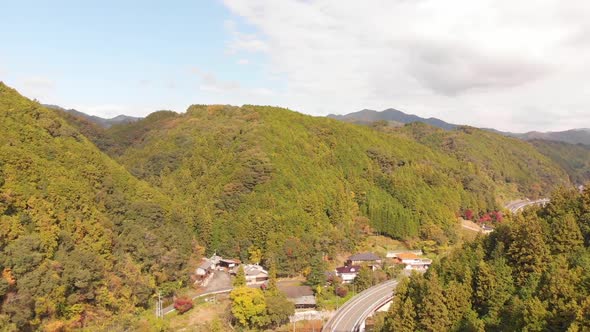 small village in the mountains with a river running through in autumn