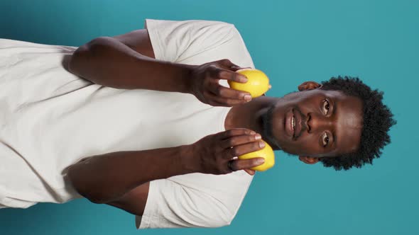 Cheerful Person Holding Lemons for Healthy Vegetarian Diet