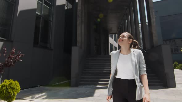 Young Happy Woman Walking and Smiling. Happy Woman in a Modern Location Among the City.