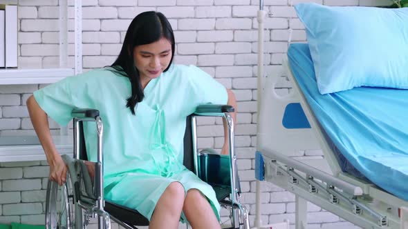 Young Happy Asian Woman on Wheelchair in a Hospital Ward