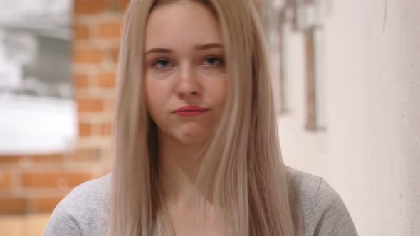 Shaking Head to No, Young Woman Sitting on Chair at Home