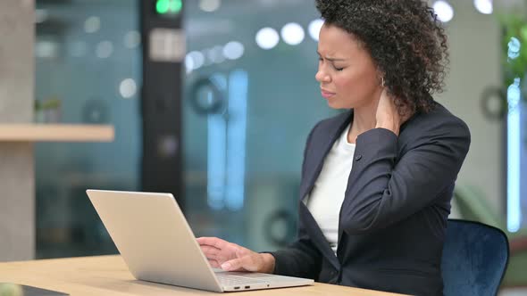 Tired African Businesswoman with Laptop Having Neck Pain at Work 