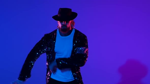 Young Stylish Man Dancing in Style, Spotlight on a Blue Background. Close Up, Slow