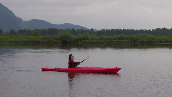 Adventure Caucasian Adult Woman Kayaking in Red Kayak