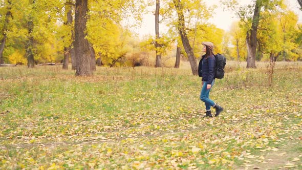 Girl Tourist on a Hike in the Autumn Forest