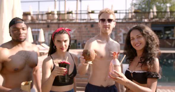 Four Friends Clinking with Cocktails at Swimming Pool