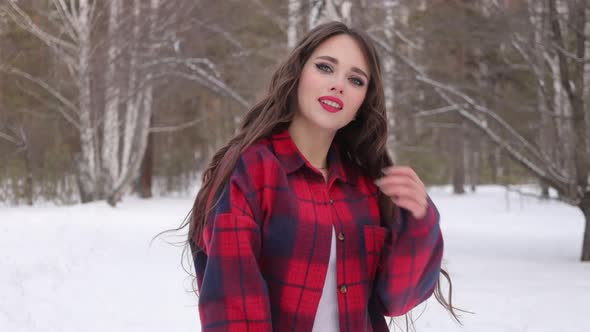 Charming Female with Long Hair Walking in Snowy Forest