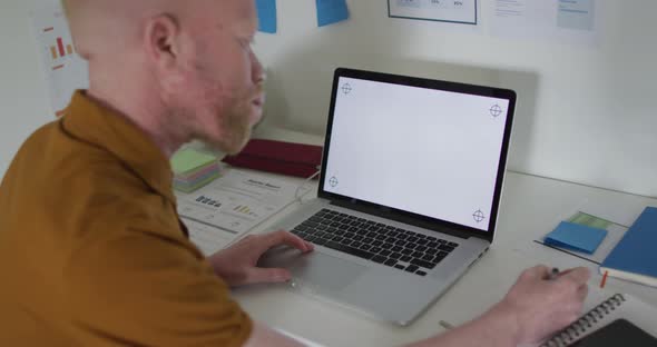 Albino african american man with dreadlocks making video call on the laptop