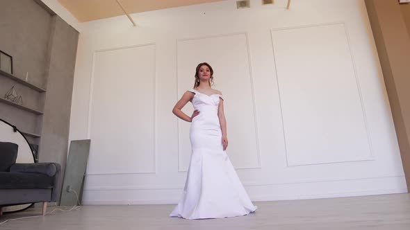 Happy Bride in White Dress Posing for the Photographer While Standing