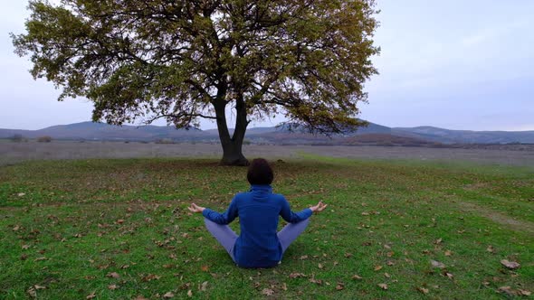 Back View of Unrecognizable Slender Young Woman in Lotus Position