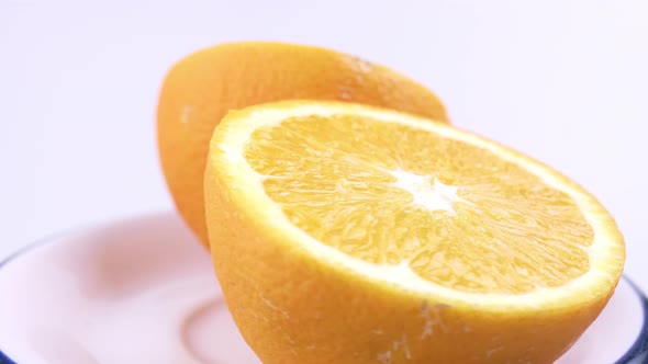 Close up fresh valencia orange sliced with white background shallow focus and slowly rotating.