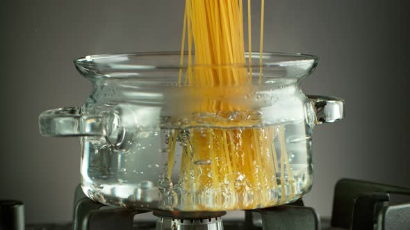 Super Slow Motion Shot of Fresh Spaghetti Falling Into Boiling Salted Water at 1000 Fps