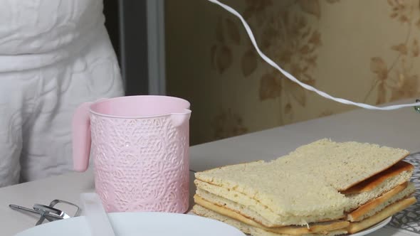 A Woman Sets Whisks On A Mixer. On The Plate Are Pieces Of Freshly Baked Biscuit.