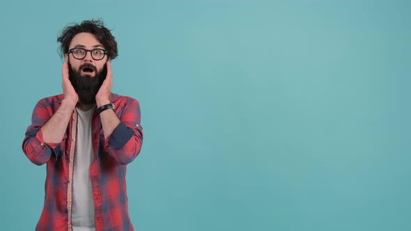 Young Bearded Man Showing Surprise and Amazed Expression with Hands on Face